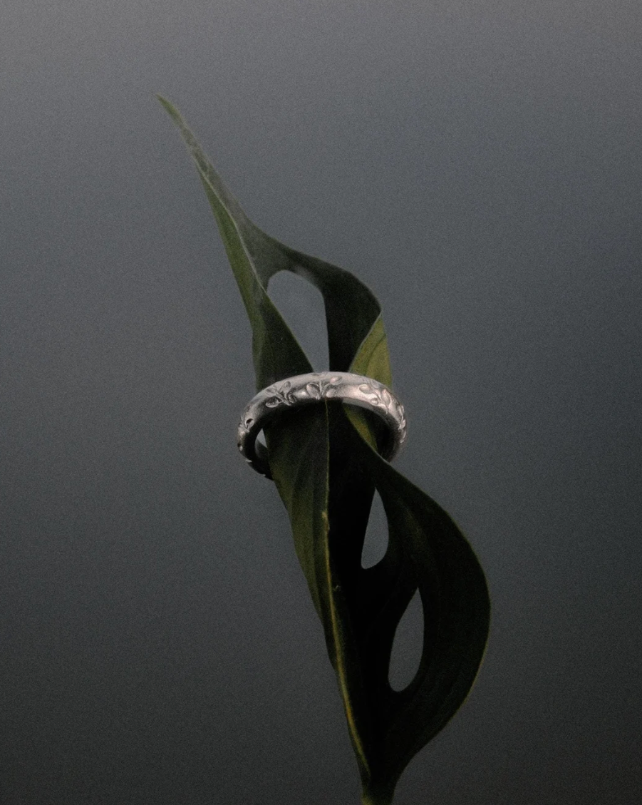 Hand with wedding, seaweed and knot rings from THEA STUDIO on a black background
