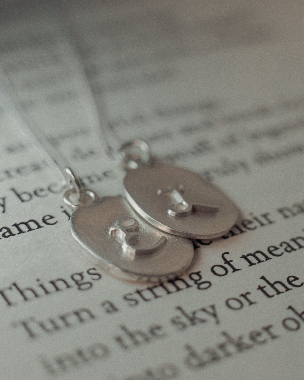 Personalised debossed initial oval silver pendants