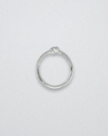 Silver ring with knot detail on a light gray background